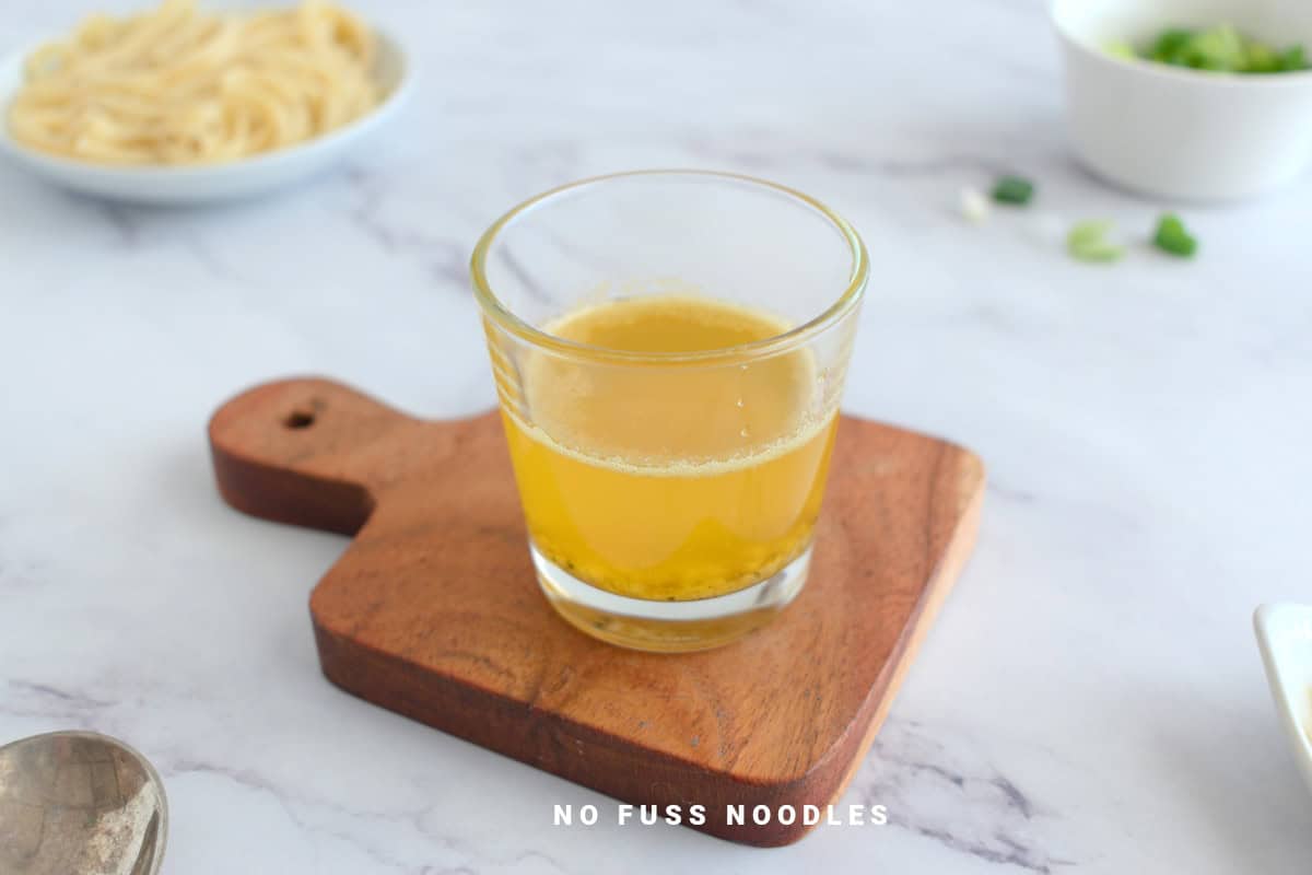 Close up image of garlic butter sauce in a glass.
