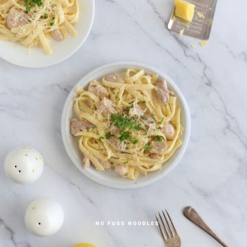 Close up image of chicken and garlic noodles in a white plate.