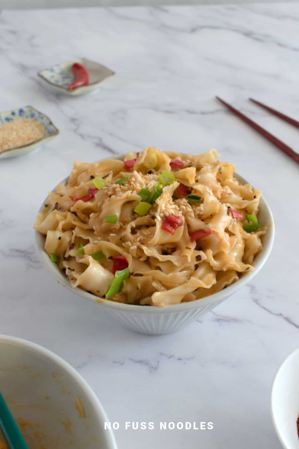 Close up image of chili oil noodles in a bowl.