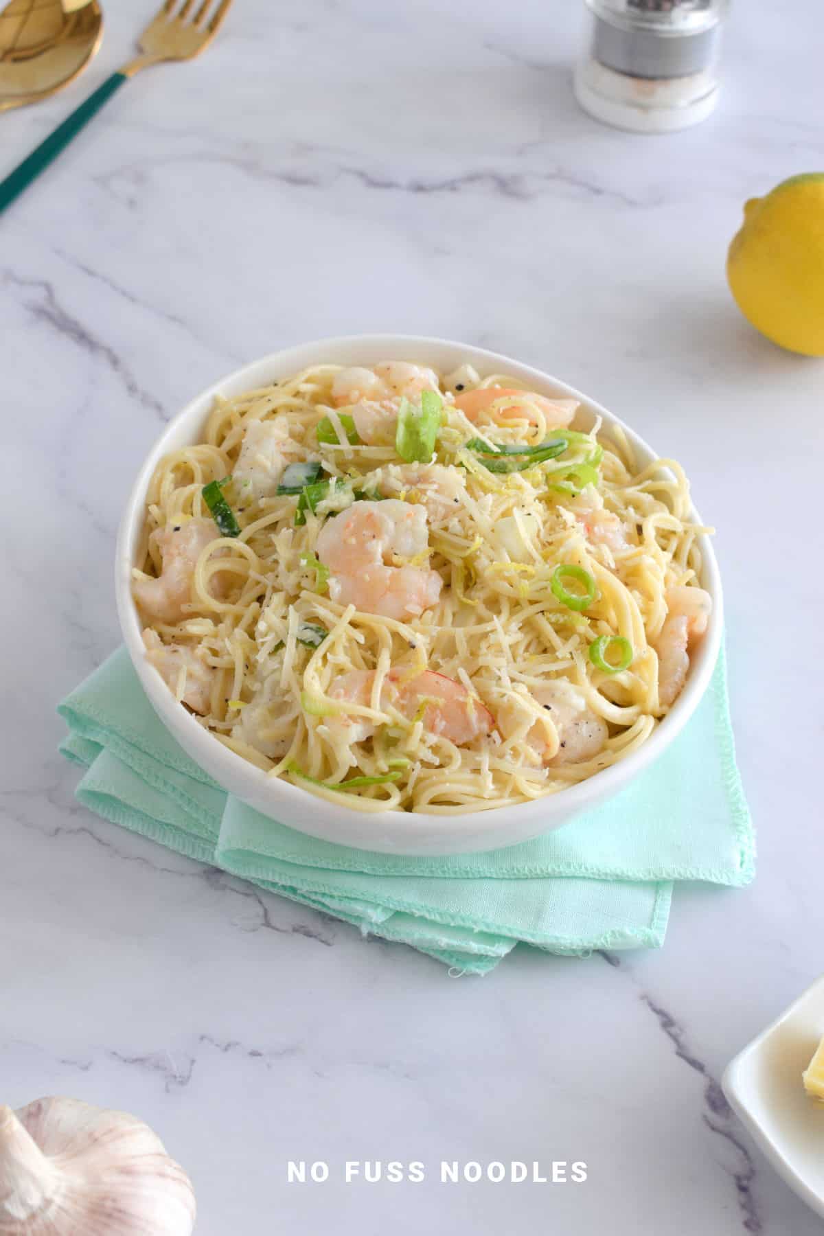 Garlic lemon shrimp in a white bowl on a napkin.