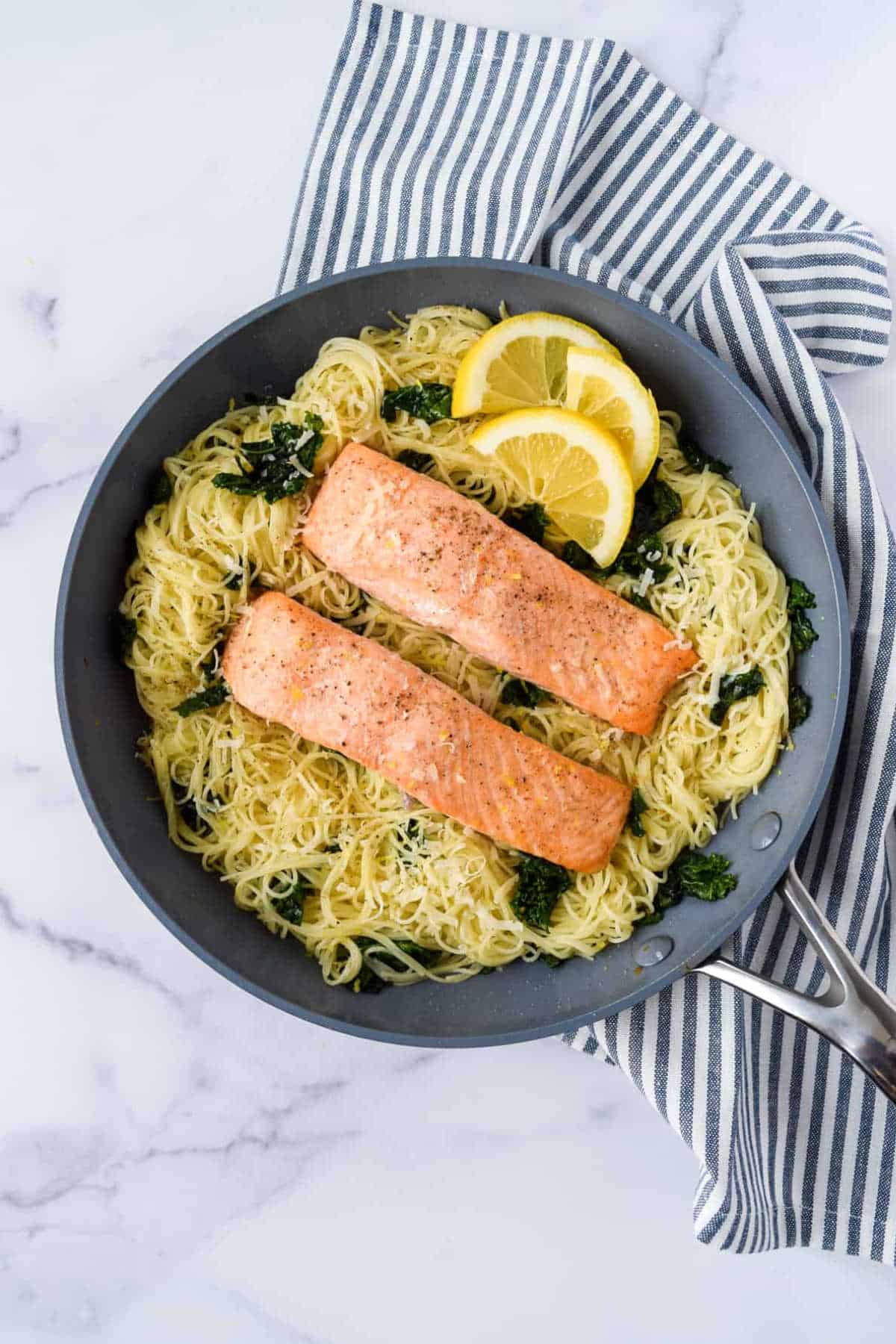 Lemon, kale, and salmon pasta in a frying pan.
