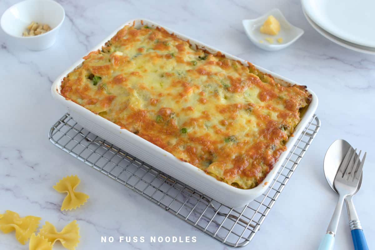 Close up image of pasta bake in a casserole dish on a wire rack.