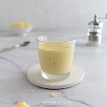 Alfredo pasta sauce in a glass.