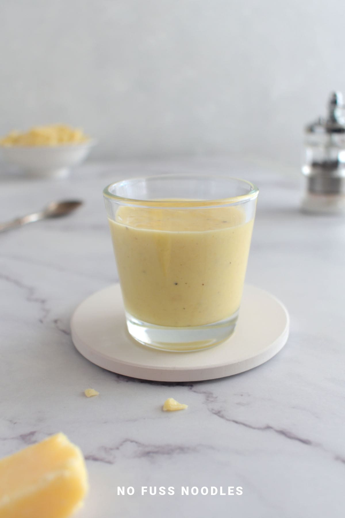 Close up image of alfredo sauce in a glass.